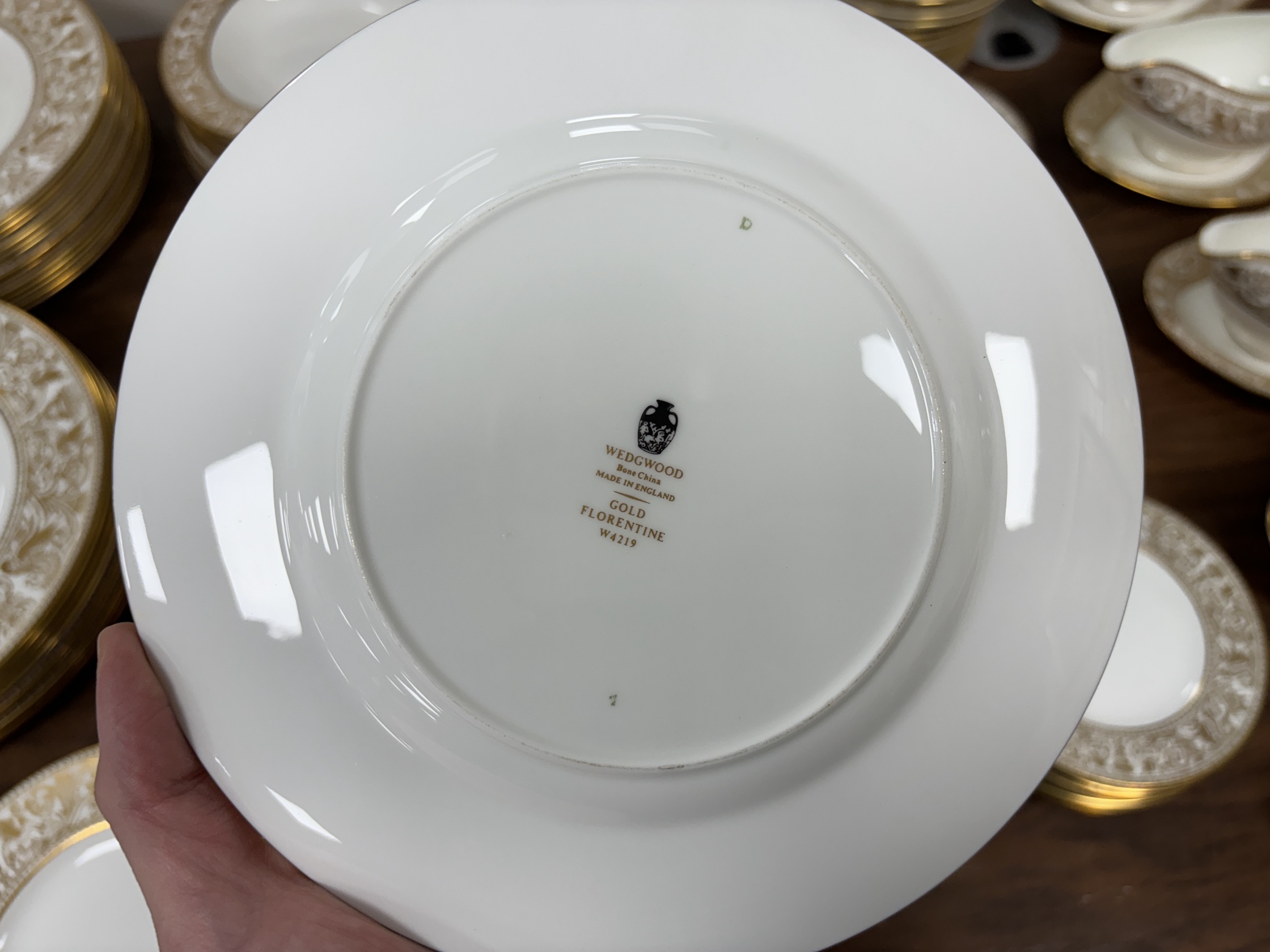 An extensive Wedgwood Gold Florentine dinner service, including 26 dinner plates, 50 side plates, 18 soup bowls with 16 saucers, 6 tea cups and 4 saucers, 6 bowls, 6 large cheese plates, 5 gravy boats and 3 saucers, 3 ve